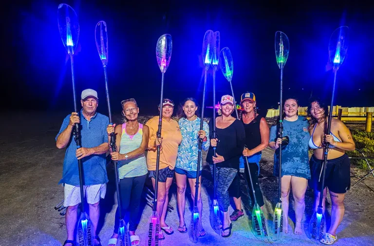 people with glowing kayak paddles