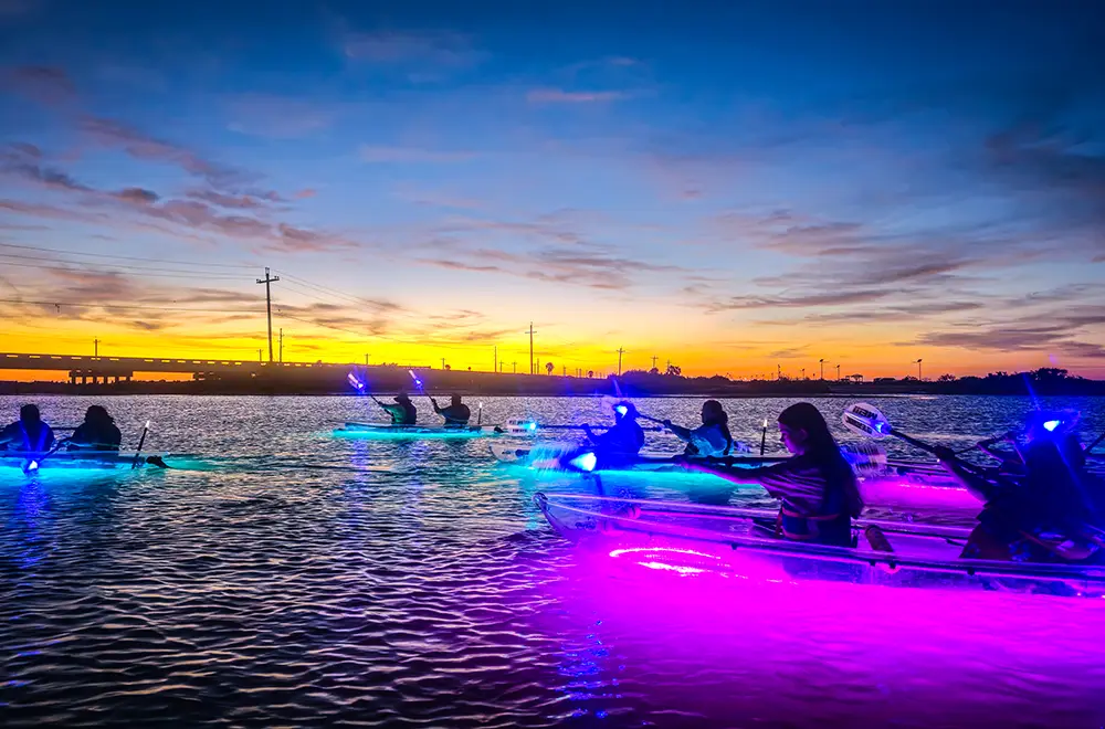 people kayaking in glowing kayak